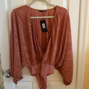 Beautiful never worn before rust color low-cut bodysuit with beautiful sleeves.